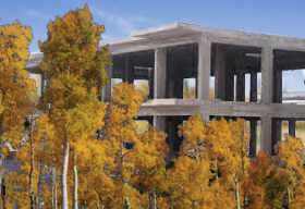 a yellow forest surrounds an unfinished concrete structure